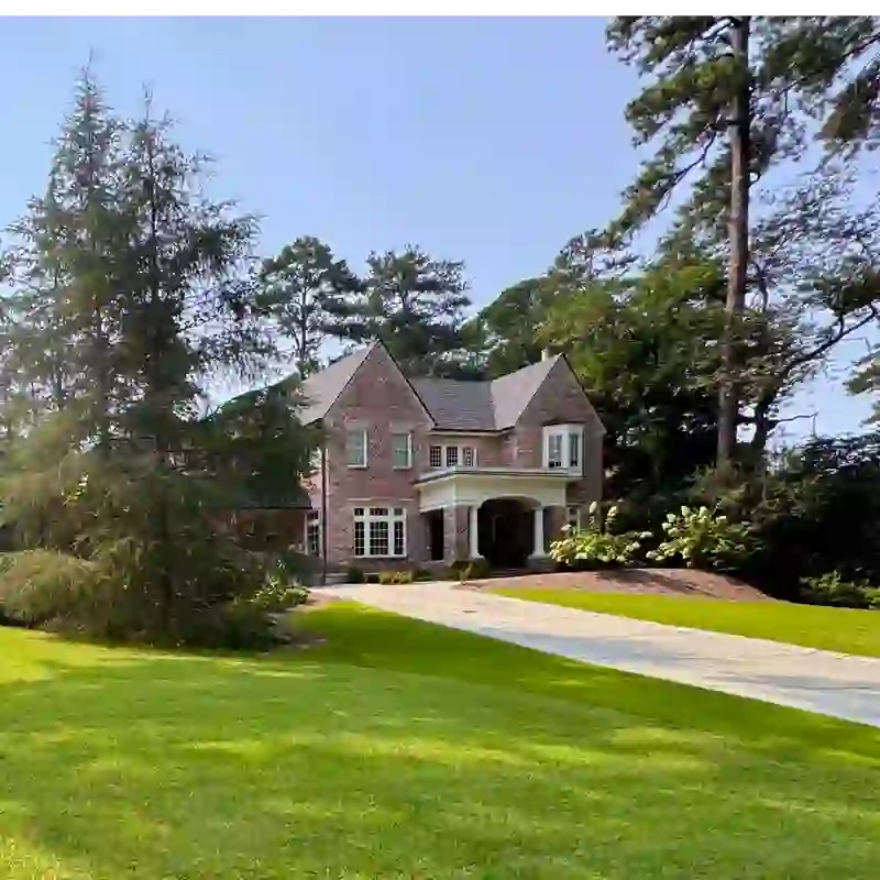 Brick Colonial home with manicured lawn and mature trees in Morningside, Atlanta GA