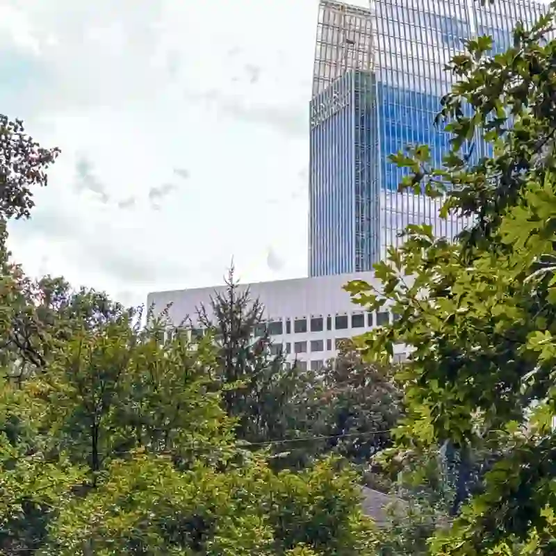 Winn Park surrounded by mature trees with the Midtown Atlanta skyline rising behind Ansley Park